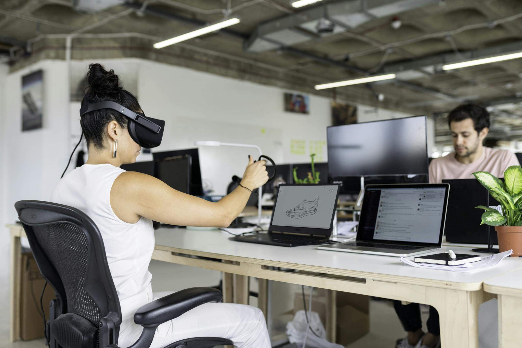 Woman using virtual reality headset in a modern office for design and innovation.